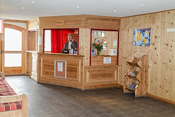 A man stands behind a counter that says accueil