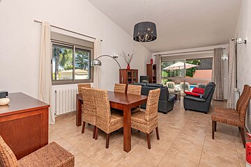 A dining room with wicker chairs and a table