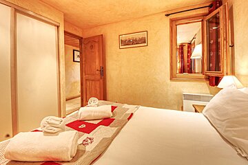 A bedroom with a picture on the wall above the bed