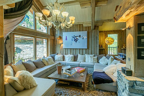 A living room with a large sectional couch and a chandelier