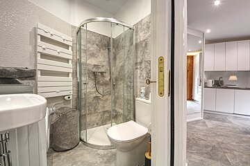 A bathroom with a walk in shower and a toilet