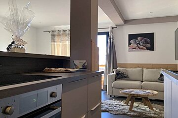 A kitchen with a stove top oven and a couch