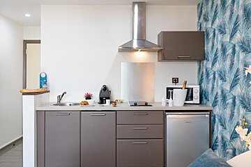 A small kitchen with a stainless steel refrigerator