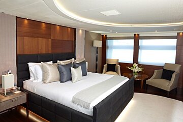 A bedroom with a large bed and two chairs
