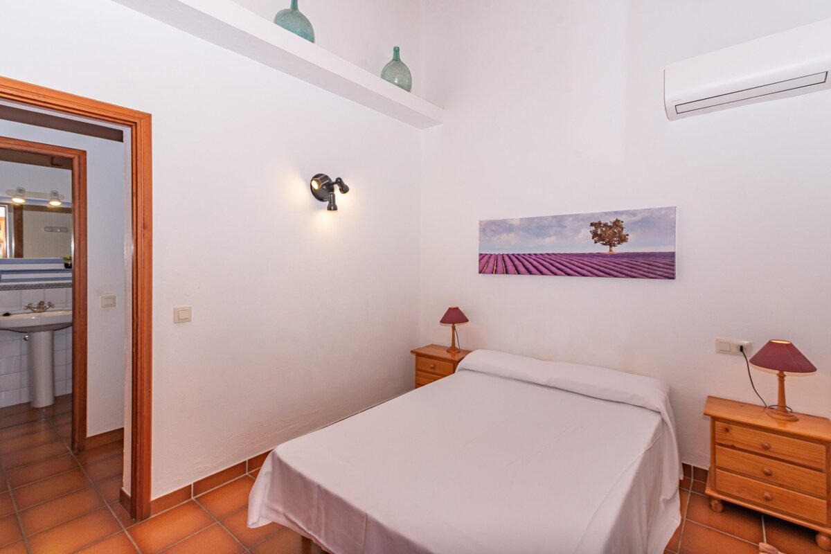 A bedroom with a painting of a tree on the wall