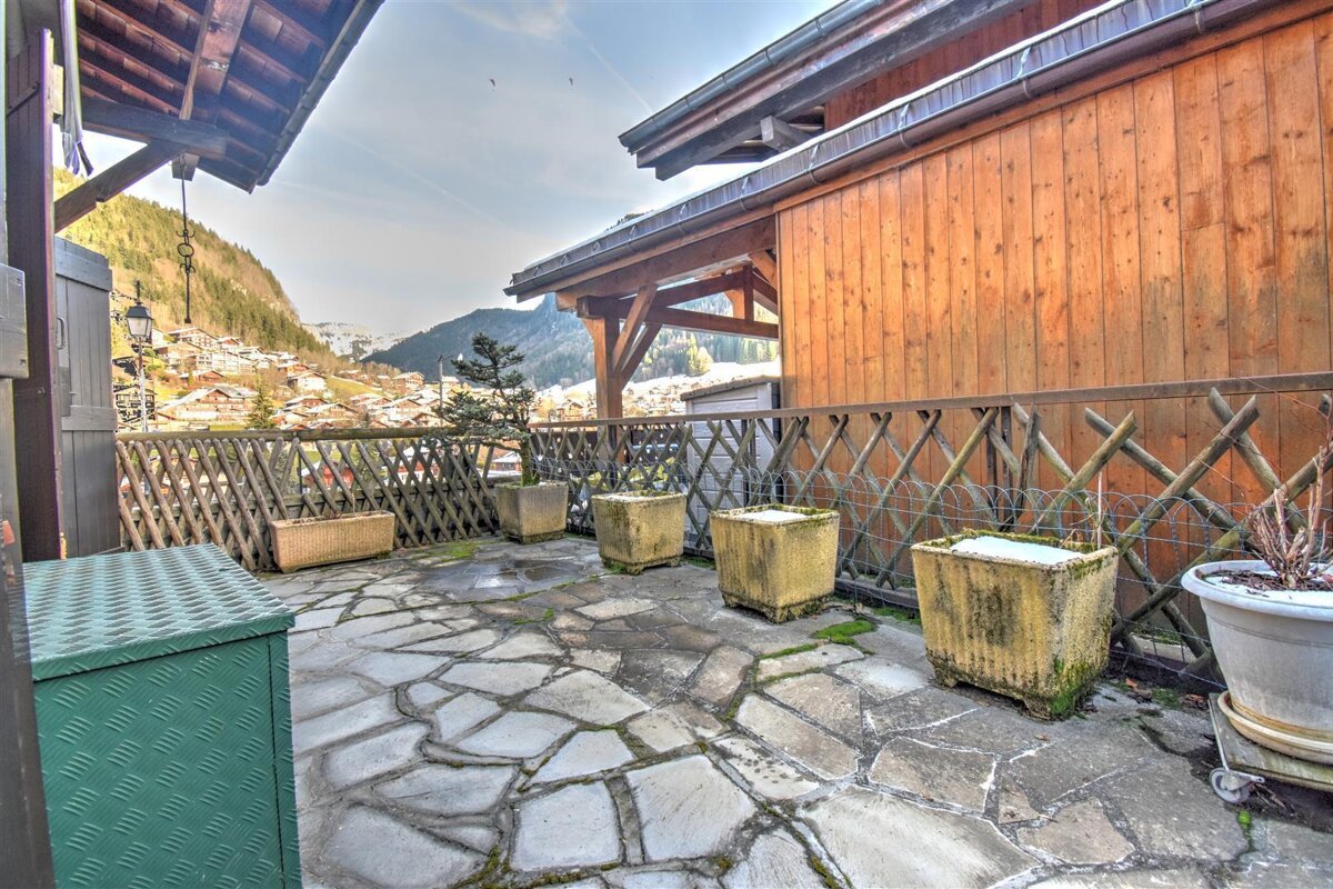 A patio with a wooden fence and potted plants