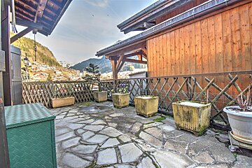 A patio with a wooden fence and potted plants