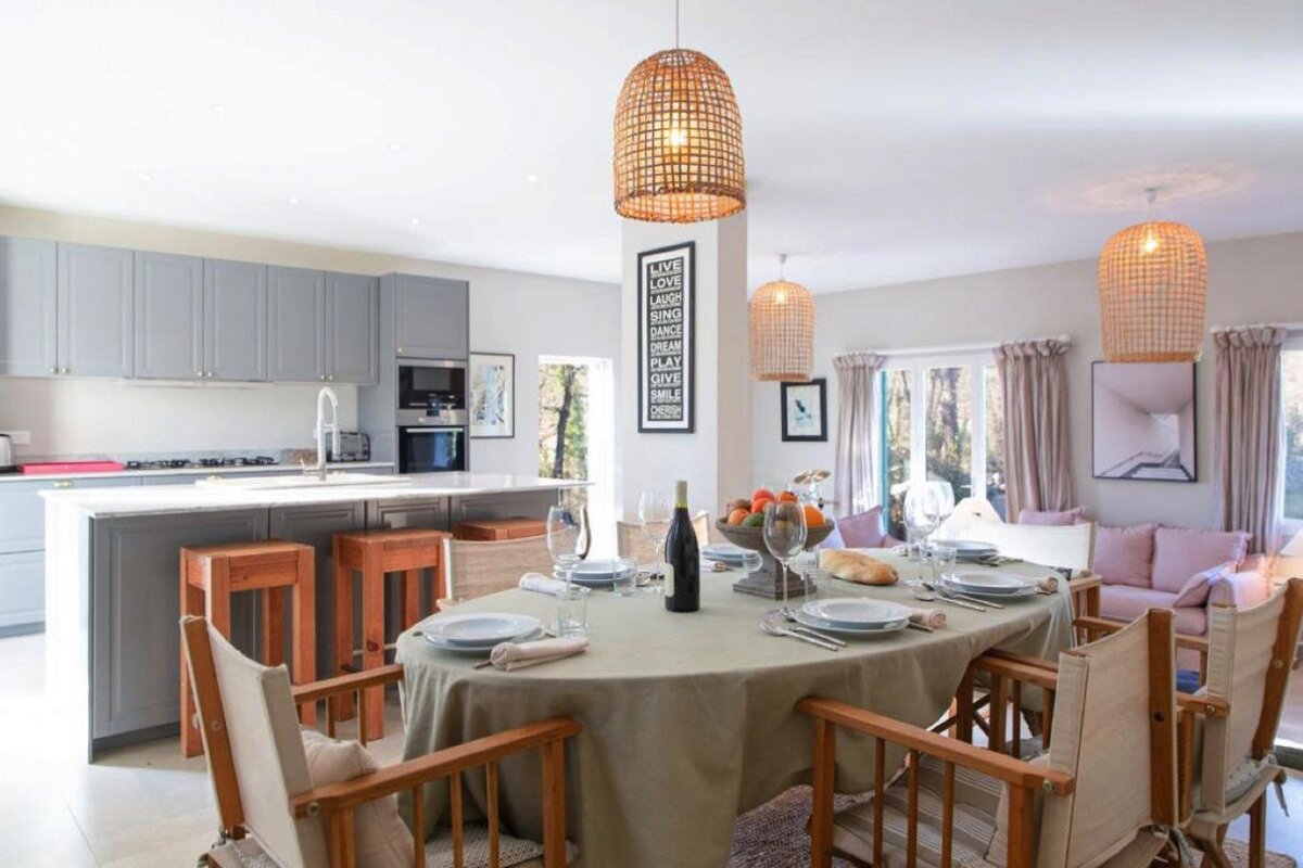 A dining room table with a bottle of wine on it