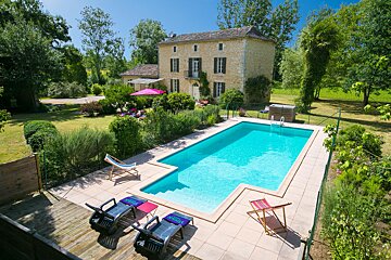 A large swimming pool in front of a large house