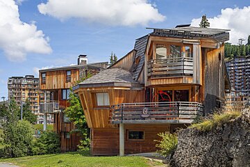 A wooden house with a balcony and a sign that says ' montagne ' on it