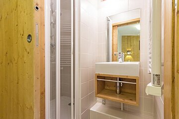 A bathroom with a sink a mirror and a towel rack