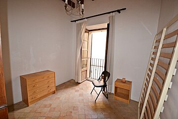 An empty room with a dresser and a chair