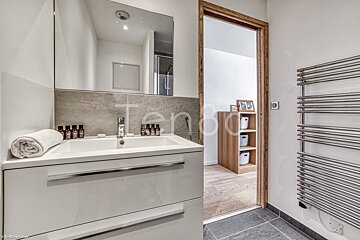 A bathroom with a sink and a towel on the counter and the word tenda on the wall