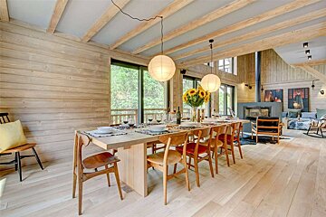 A dining room table with a vase of sunflowers on it