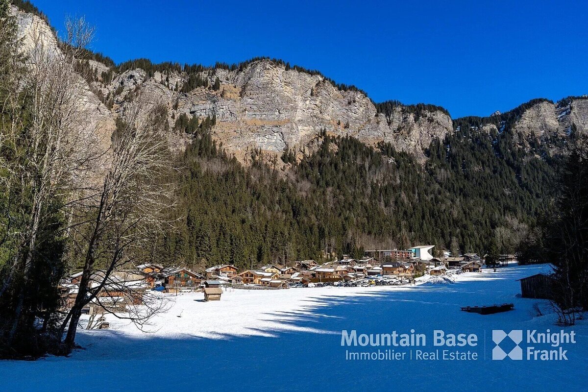 A snowy landscape with the words mountain base immobilier real estate on the bottom
