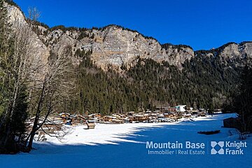 A snowy landscape with the words mountain base immobilier real estate on the bottom
