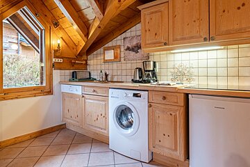 A kitchen with a washing machine and a thomson dishwasher