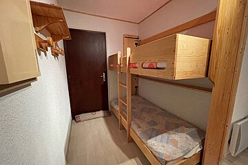 A bunk bed in a small room with a door