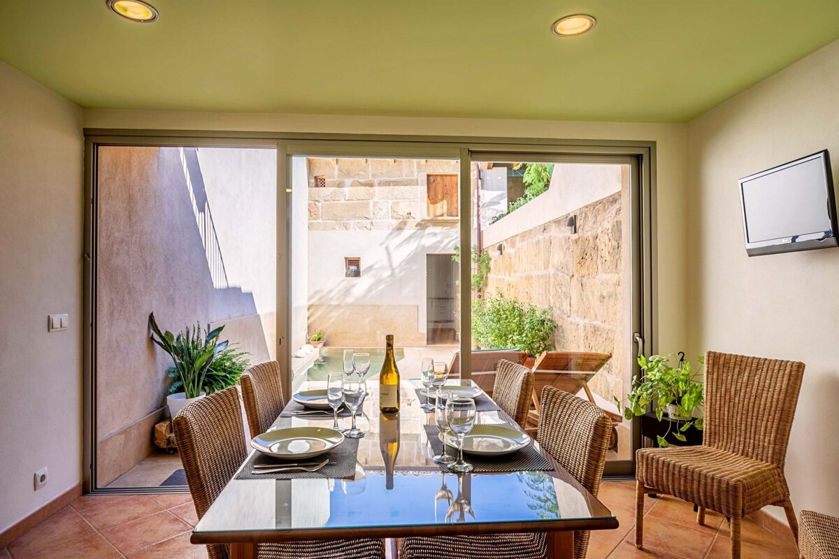 A dining room table with a bottle of wine on it