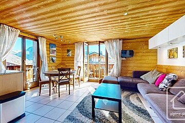 A living room with a couch a table and chairs and a sign that says alpine-pro