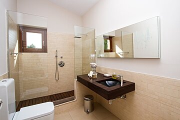 A bathroom with a walk in shower and a sink
