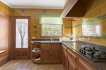 A kitchen with two sinks and a stove top oven
