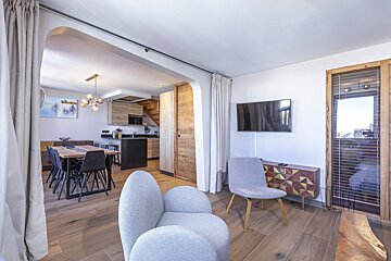 A living room with a chair and a flat screen tv
