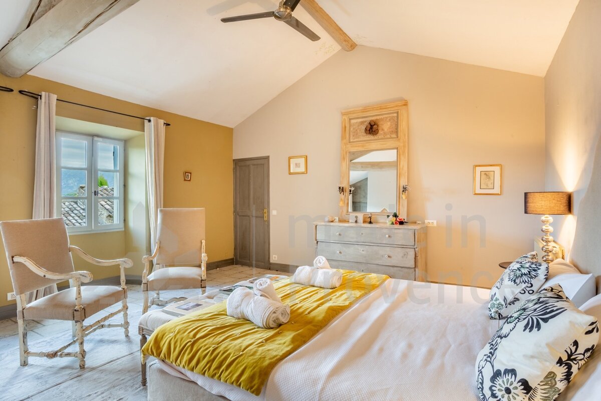 A bedroom with a large bed and a dresser