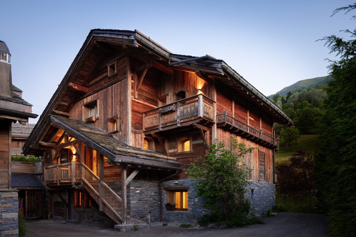 A large wooden house with stairs leading up to it