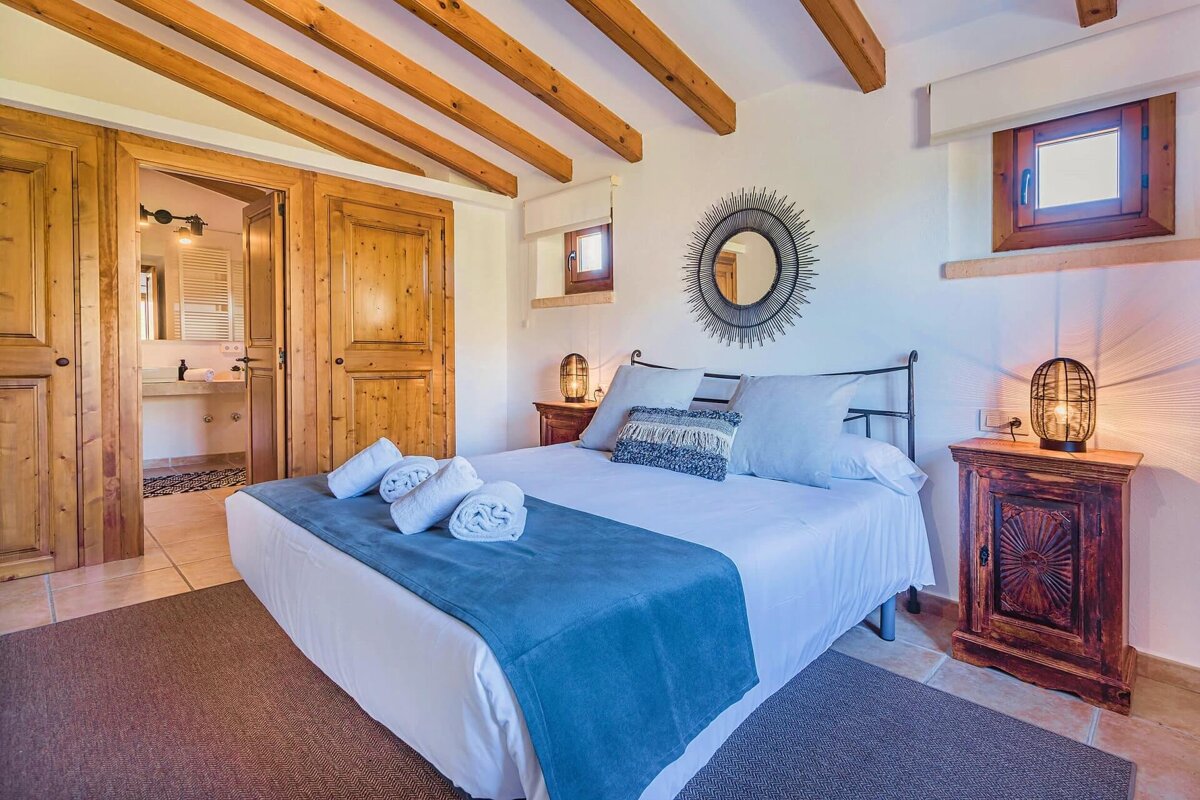 A bedroom with a large bed and a mirror on the wall