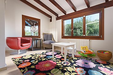 A room with a floral rug and a red chair