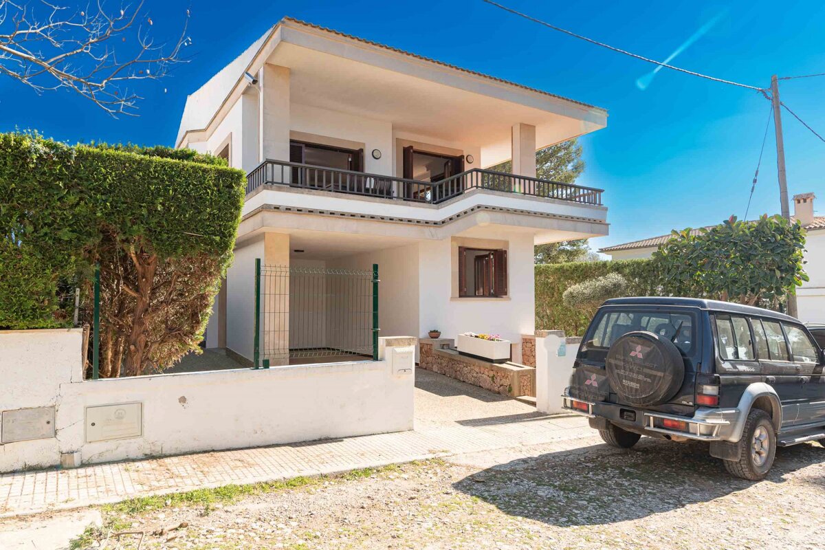 A mitsubishi suv is parked in front of a house