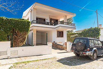 A mitsubishi suv is parked in front of a house