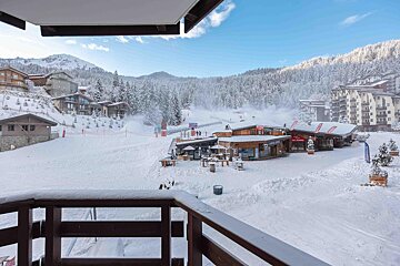 A view of a snowy ski resort from a balcony