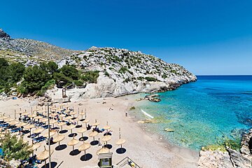 A beach with lots of umbrellas and chairs