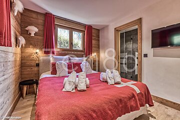 A bedroom with a large bed and a swiss flag blanket