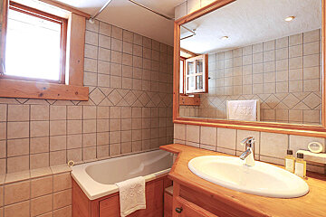 A bathroom with a bathtub and a sink and a mirror
