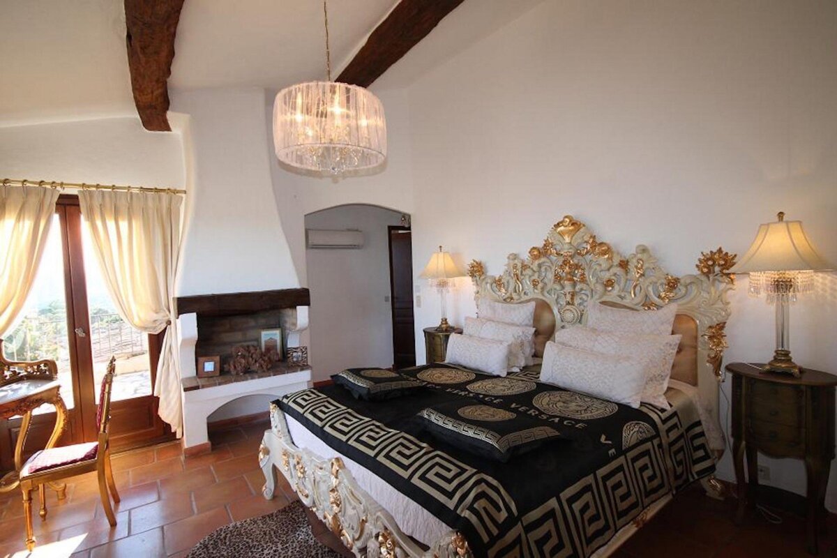 A bed with a versace blanket on it