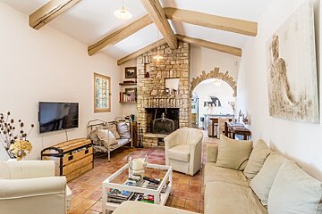 A living room with a stone fireplace and a flat screen tv
