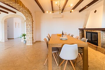 A dining room with a table and chairs and a fireplace