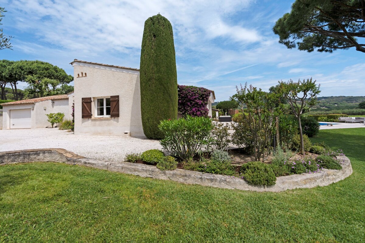 A white house with a few trees in front of it