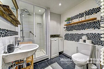 A bathroom with a toilet and sink and a sign that says mountain base immobilier real estate