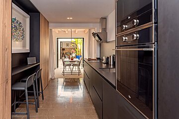 A kitchen with black cabinets and black appliances
