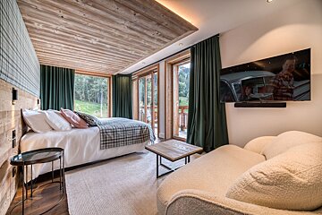 A bedroom with a bed and a flat screen tv