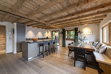A kitchen and dining area with a wooden ceiling