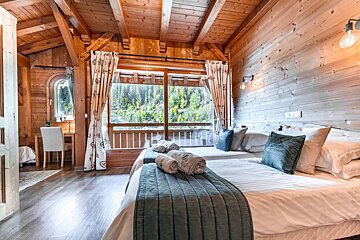 A bedroom with two beds and a large window