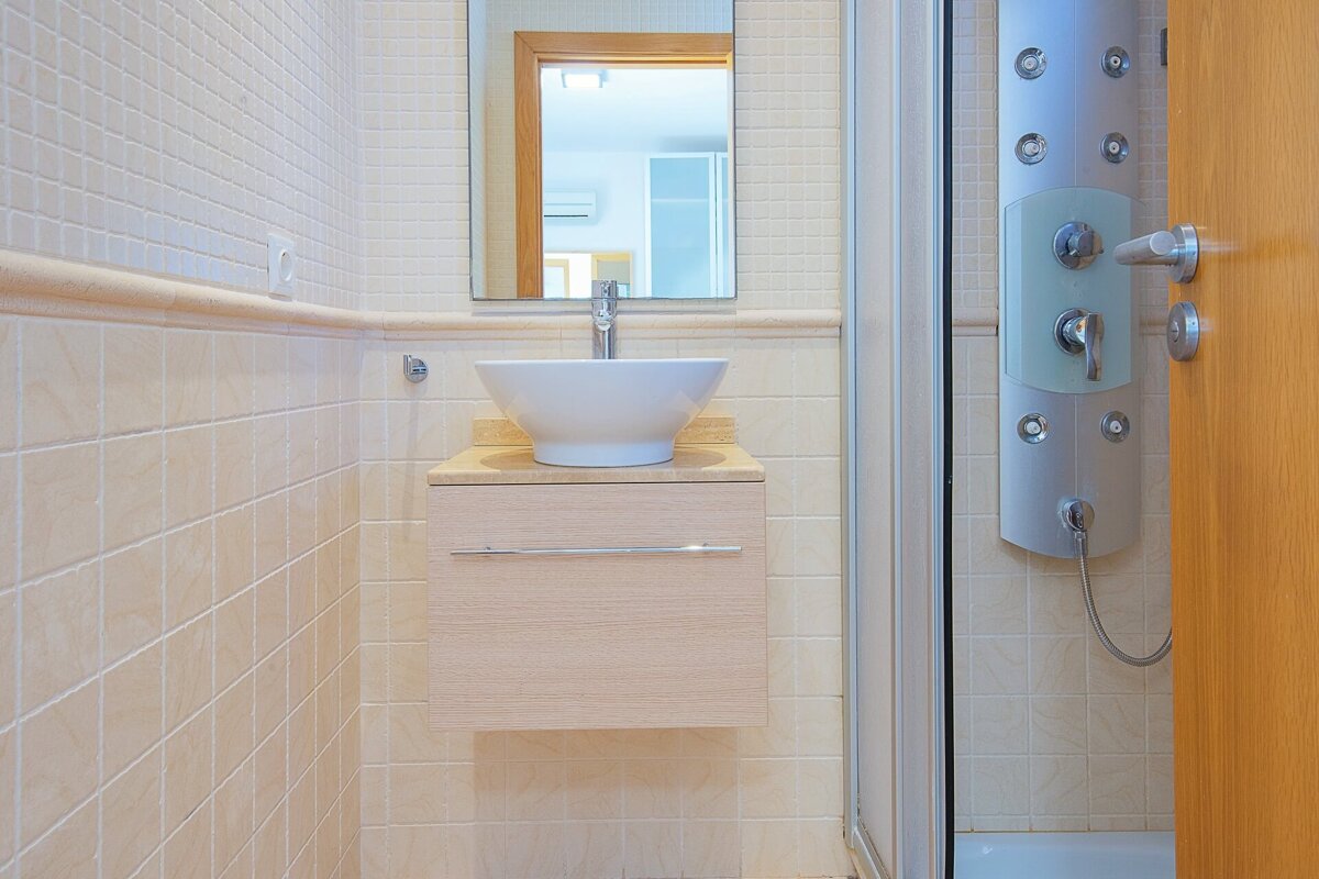 A bathroom with a sink and a shower stall