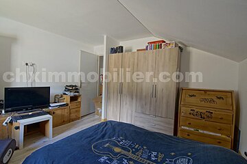 A bedroom with the website chximmobilier.com in the corner