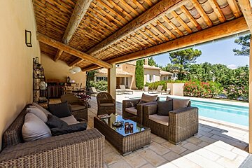 A patio area with wicker furniture and a swimming pool