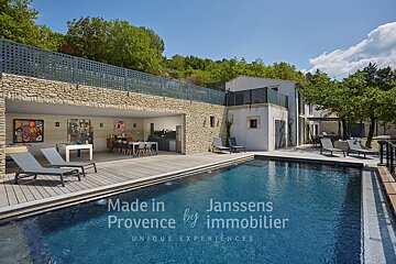 A large swimming pool in front of a house that says made in provence by immobilier